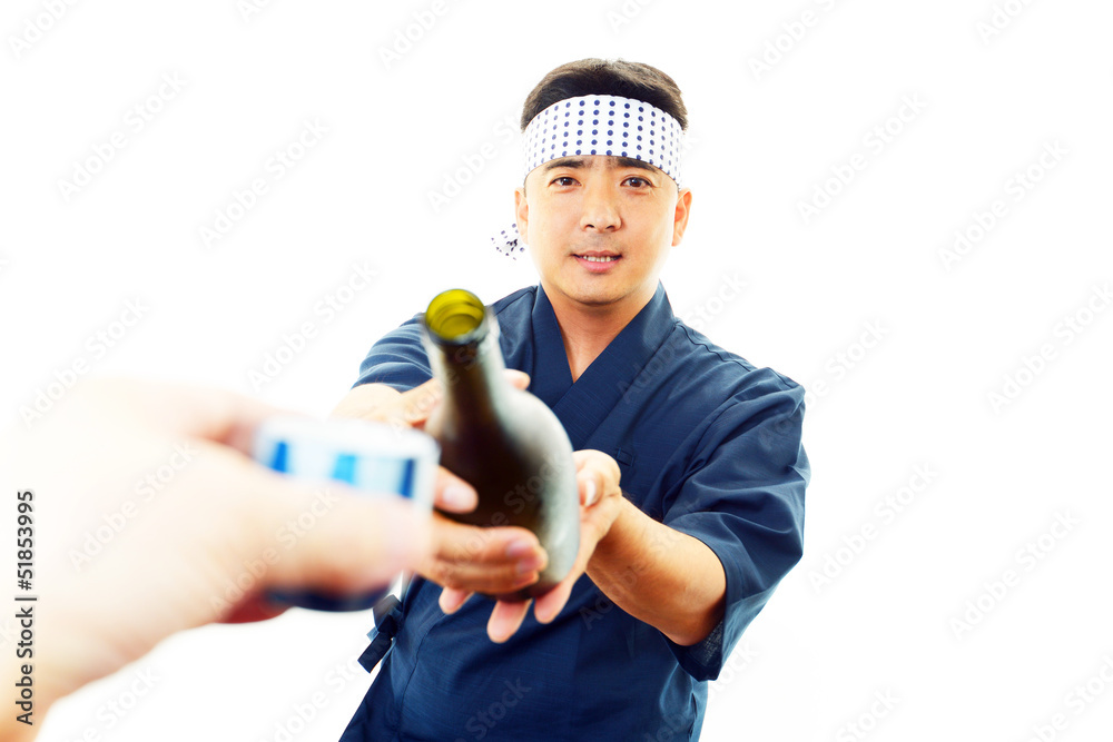 日本酒を持つ笑顔の寿司職人