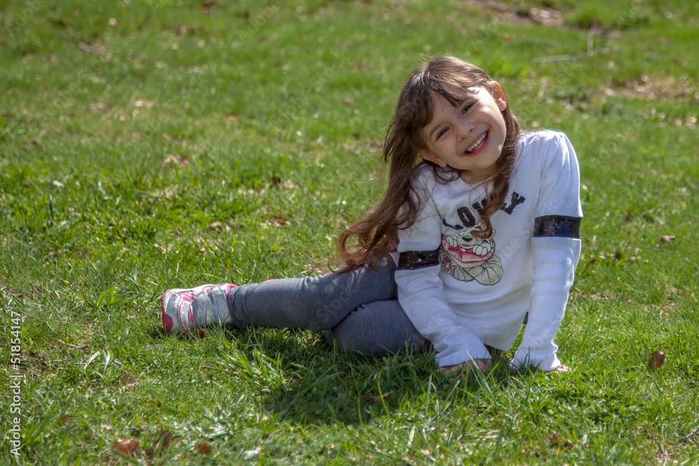 Fototapeta premium Dolce bambina seduta nel prato