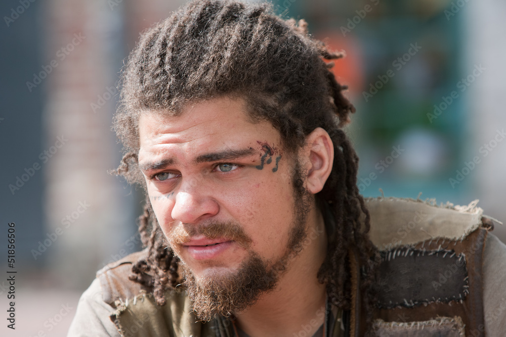 Naklejka premium Portrait young rebel with dreadlocks and tattoos