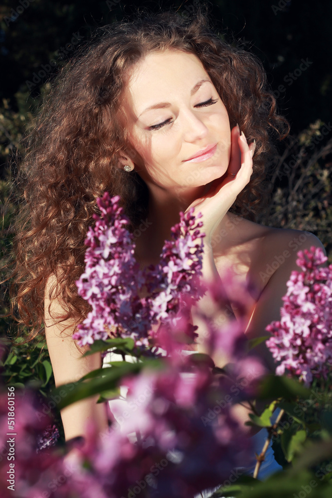 Beautiful woman on a sunny day, sitting in the flowers of lilac. Beautiful woman on a sunny day, sitting in the flowers of lilac.
