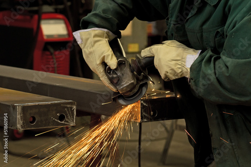 factory worker using electric grinder