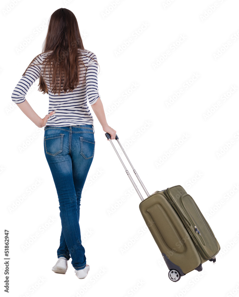 Back view of stylishly dressed brunette woman with suitcase lo Back view of stylishly dressed brunette woman with suitcase lo