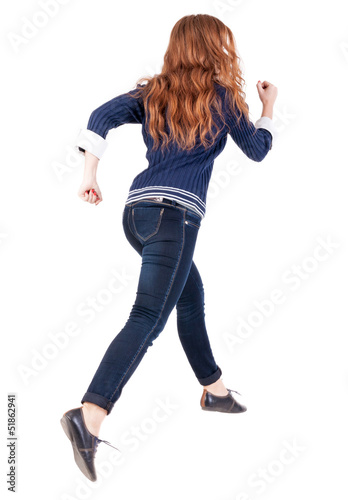 back view of jumping woman in jeans.
