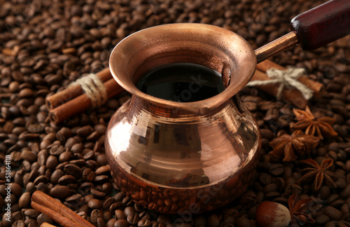 Pot of coffee on coffee beans background
