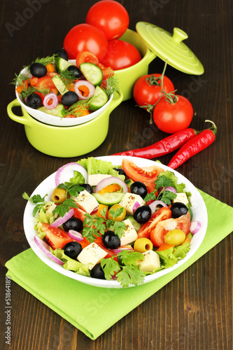 Greek salad in plate on wooden table