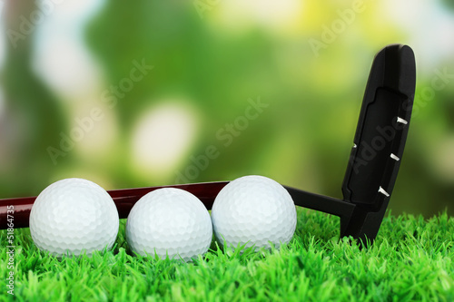 Golf balls and driver on green grass outdoor close up