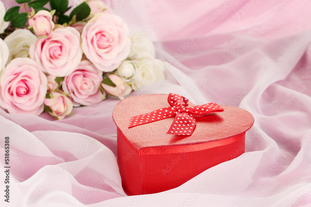 Beautiful gift on flowers background