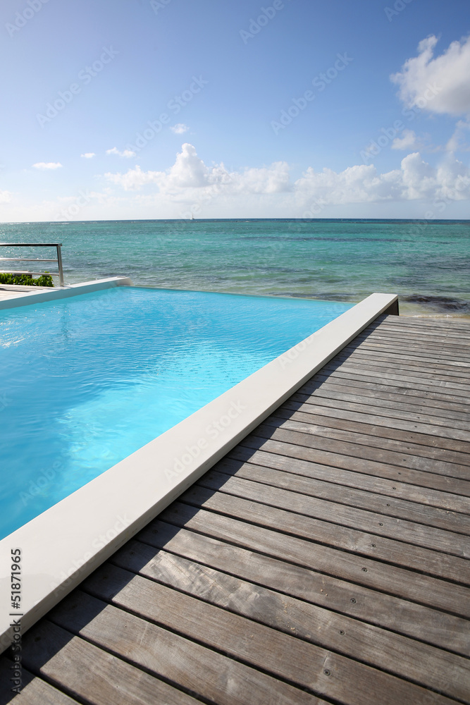 Beautiful view of infinity pool with wooden deck