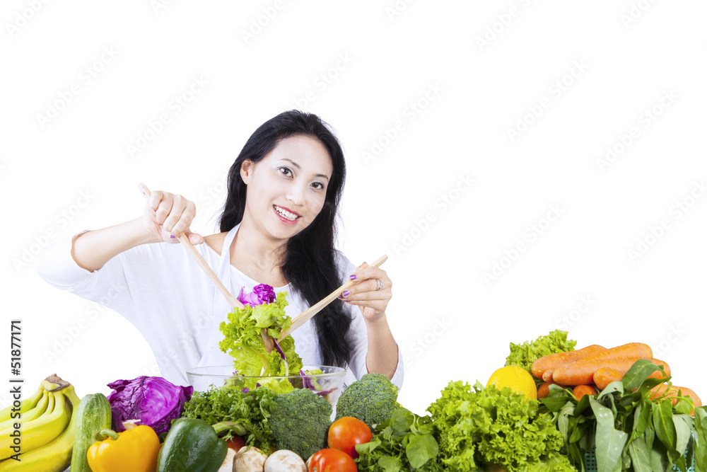 Beautiful woman makes salad on white Beautiful woman makes salad on white