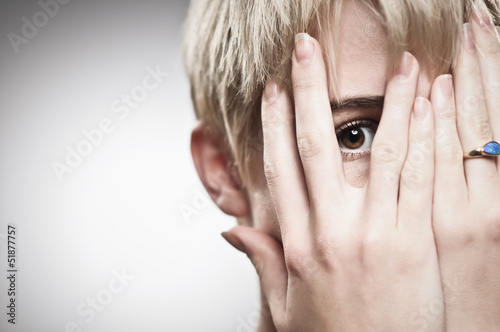Beautiful Young Caucasian Woman Peeking Through Fingers photo