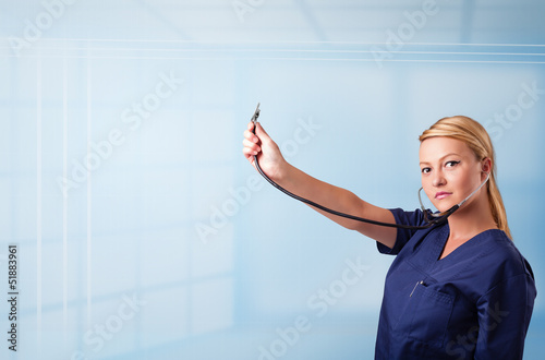 Pretty nurse in hospital listening to empty copy space with sthe