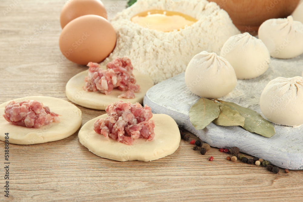 Raw dumplings, ingredients and dough, on wooden table Raw dumplings, ingredients and dough, on wooden table