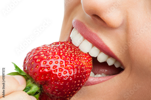 Платно Extreme close up of teeth biting strawberry.