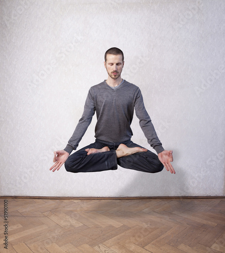 young man levitating in yoga position, meditation photo