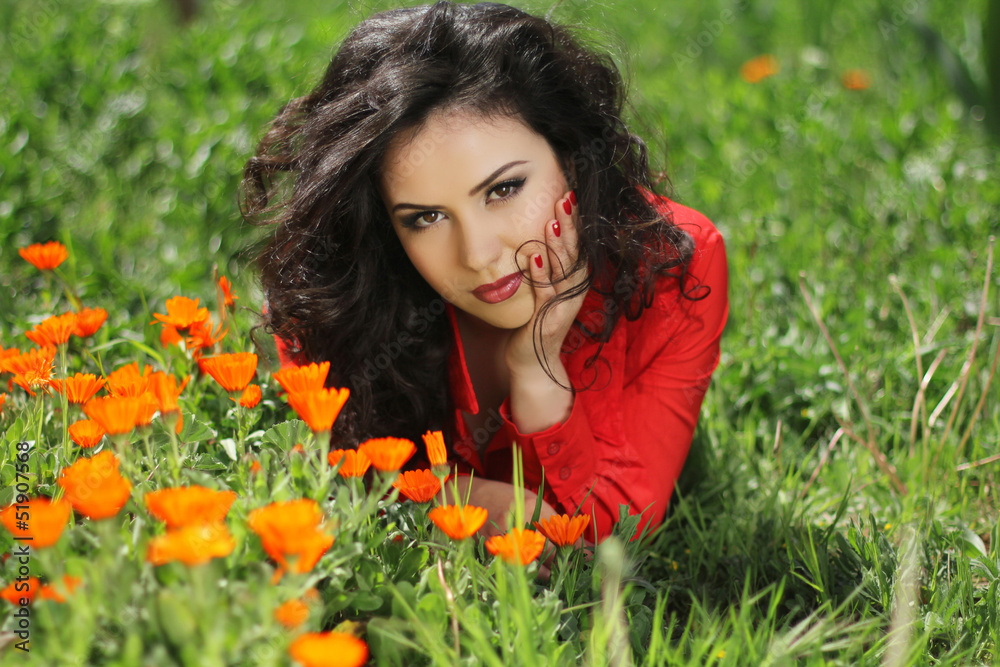 Woman in red resting on green grass, outdoors portrait Woman in red resting on green grass, outdoors portrait