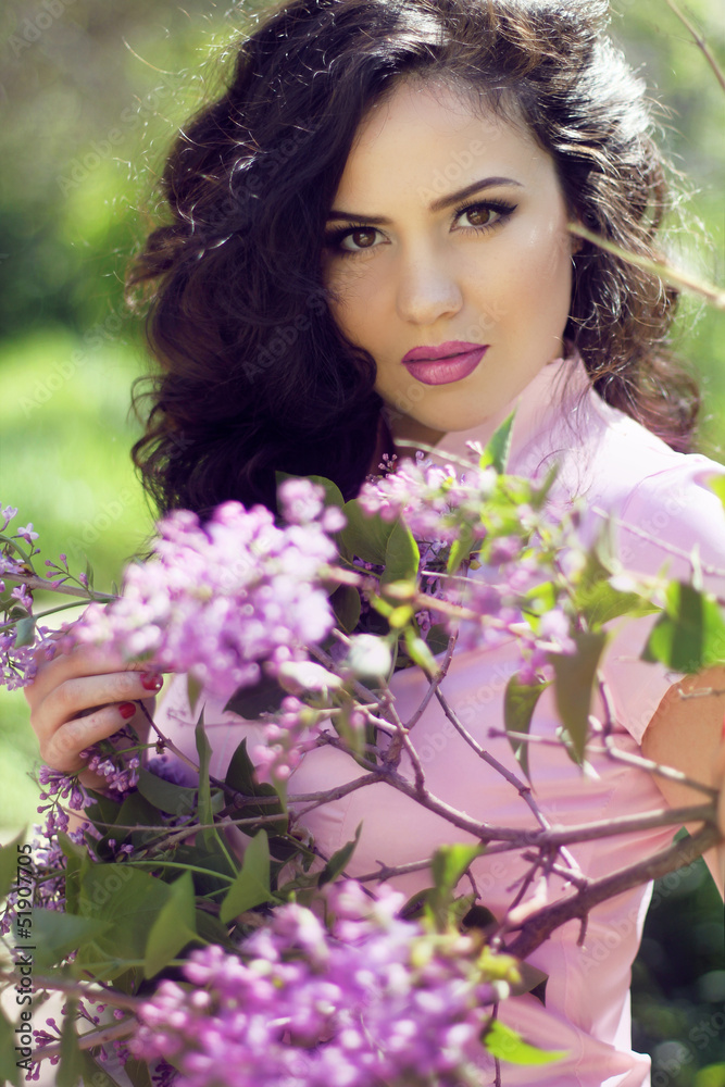 Young brunette woman with lilac flowers, Outdoors portrait