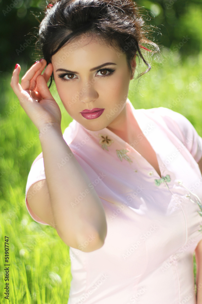 Portrait of Beautiful Brunette Young Woman resting over green gr Portrait of Beautiful Brunette Young Woman resting over green gr