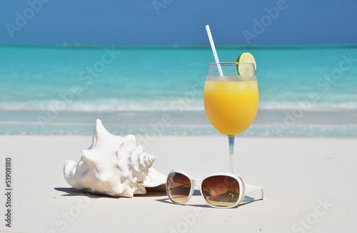 Orange juice and sunglasses on the beach. Exuma, Bahamas