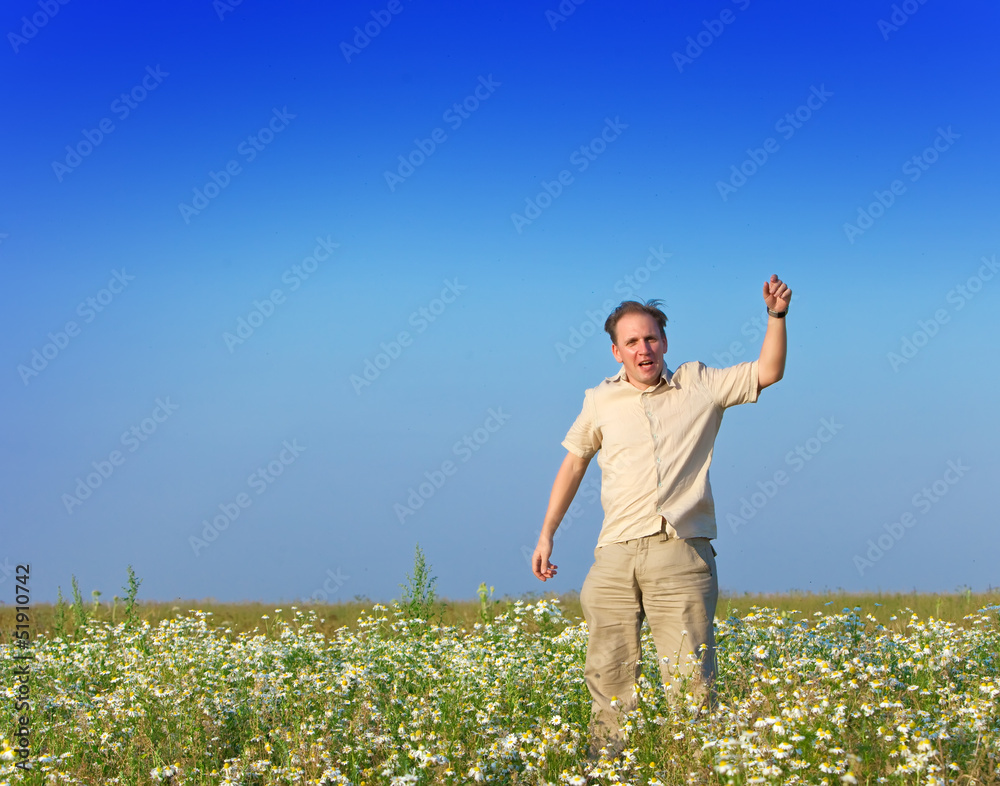 The happy young man jumps in the field of chamomiles The happy young man jumps in the field of chamomiles