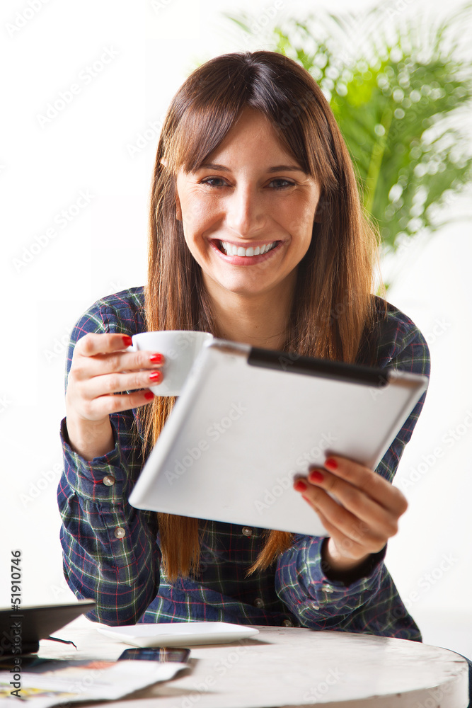 Smiling young woman with a coffee and subject a tablet Smiling young woman with a coffee and subject a tablet