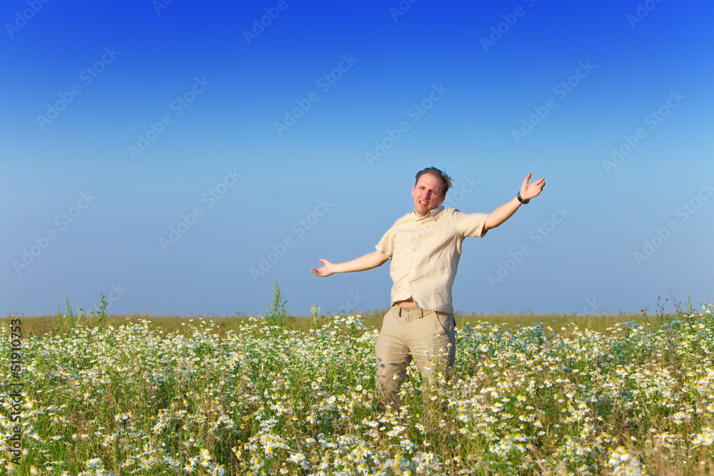 The happy young man in the field of chamomiles The happy young man in the field of chamomiles