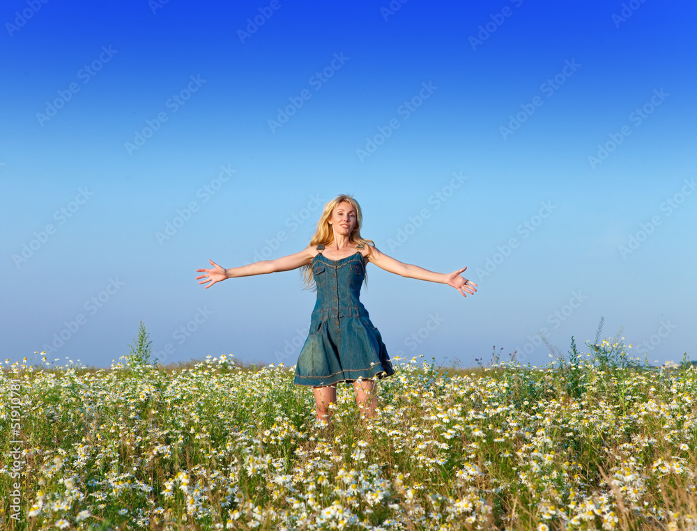 The beautiful happy young woman in the field of chamomiles.. The beautiful happy young woman in the field of chamomiles..