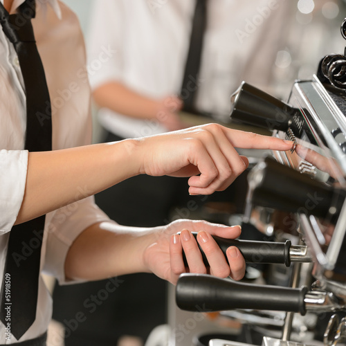 Waitress operating espresso machine coffee house