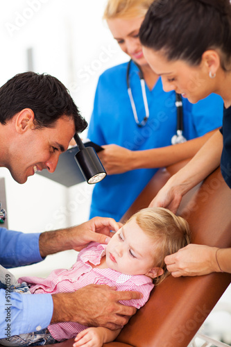 pediatrician examining little girl's ear