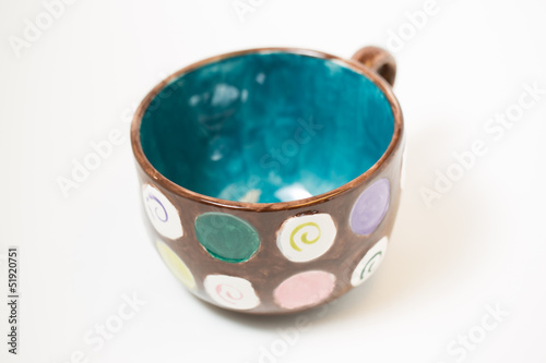 hand painted mug in a studio. focus on front rim of mug