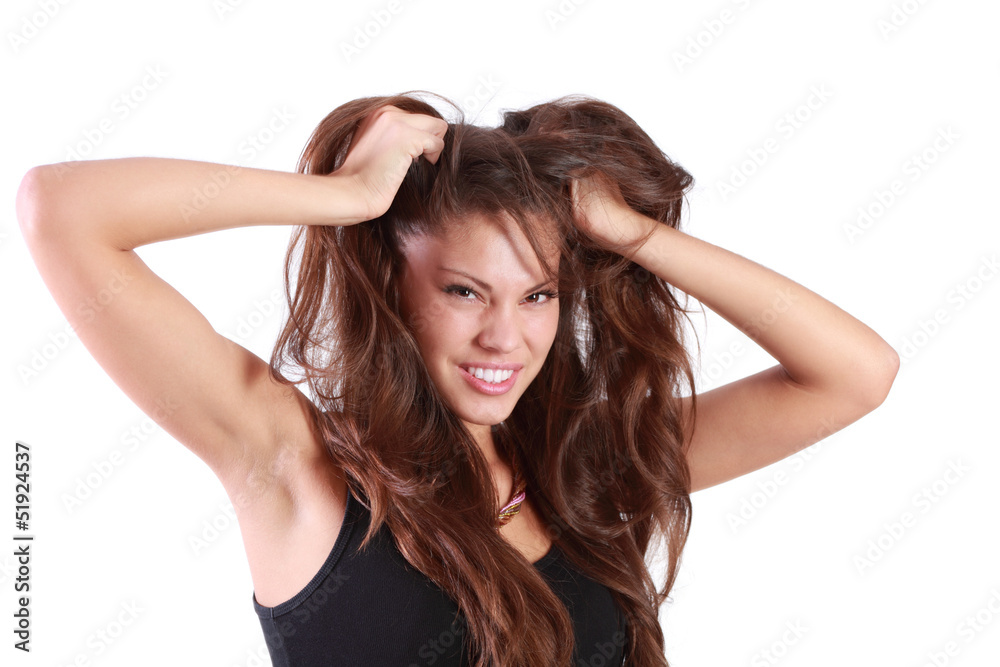 Young angry woman tears her hair and looks at camera