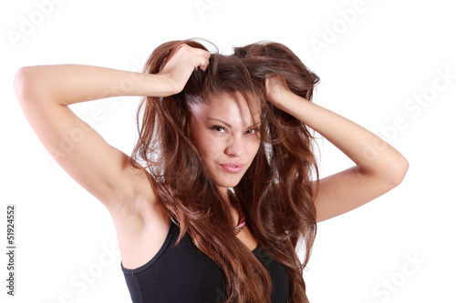 Young brunette woman tears her hair and looks at camera