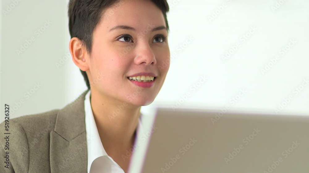 Asian business woman smiling and talking to colleague Asian business woman smiling and talking to colleague
