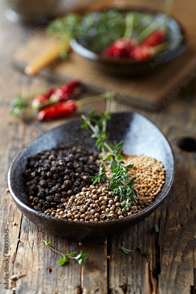 Assorted spices and fresh thyme in a ceramic dish Assorted spices and fresh thyme in a ceramic dish