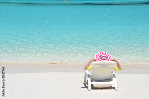 Girl in a striped hat on the beach of Exuma  Bahamas