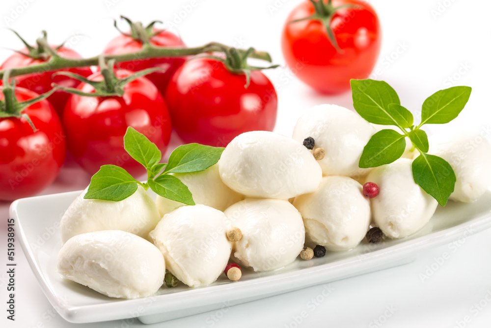 Mozzarella, tomatoes and fresh basil leaves on white background