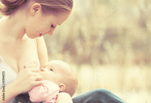 mother feeding her baby in nature outdoors in the park