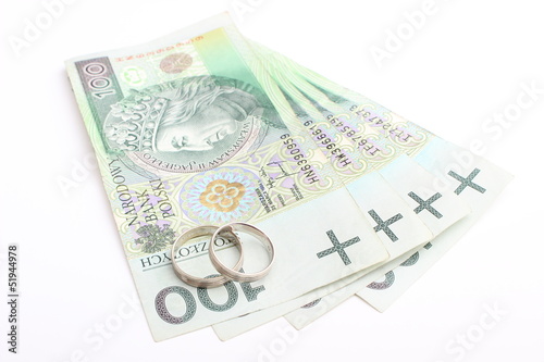 Wedding rings and money on a white background © ratmaner
