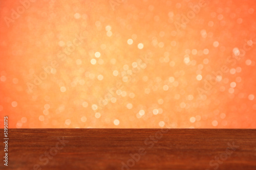 Wooden table on orange background