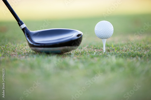 Closeup of a golf club and a golf ball ready for tee off