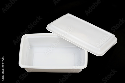 open white plastic food container over black background