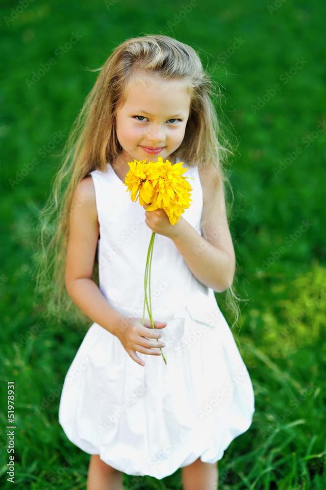 Sweet little girl with smell flower in a park - outdoor portrait Sweet little girl with smell flower in a park - outdoor portrait
