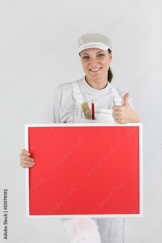 Female decorator with a board left blank for your message Female decorator with a board left blank for your message