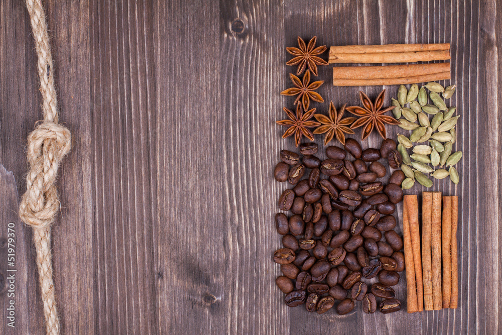 Coffee beans, cinnamon, star anise, cardamom on wood background Coffee beans, cinnamon, star anise, cardamom on wood background