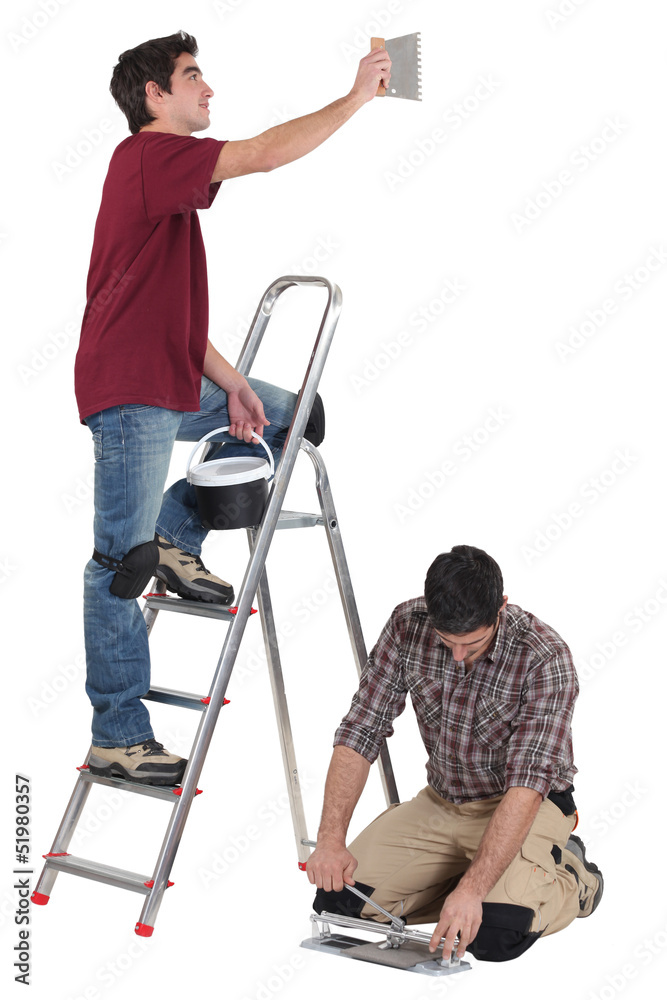 tiler and apprentice working together tiler and apprentice working together