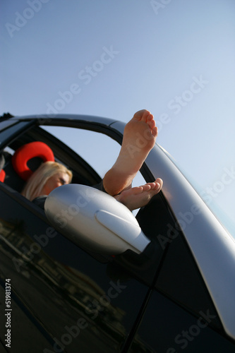 Blond woman relaxing in convertible car