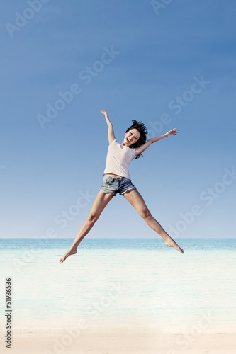 Girl jumping under blue sky
