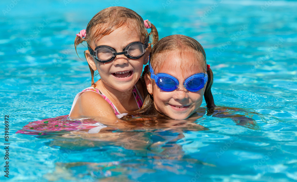 two happy little girls  in the pool