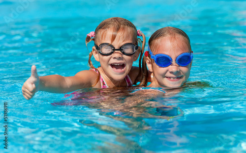 two happy little girls  in the pool © altanaka