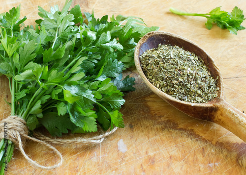 Fresh  and dry parsley on wooden background