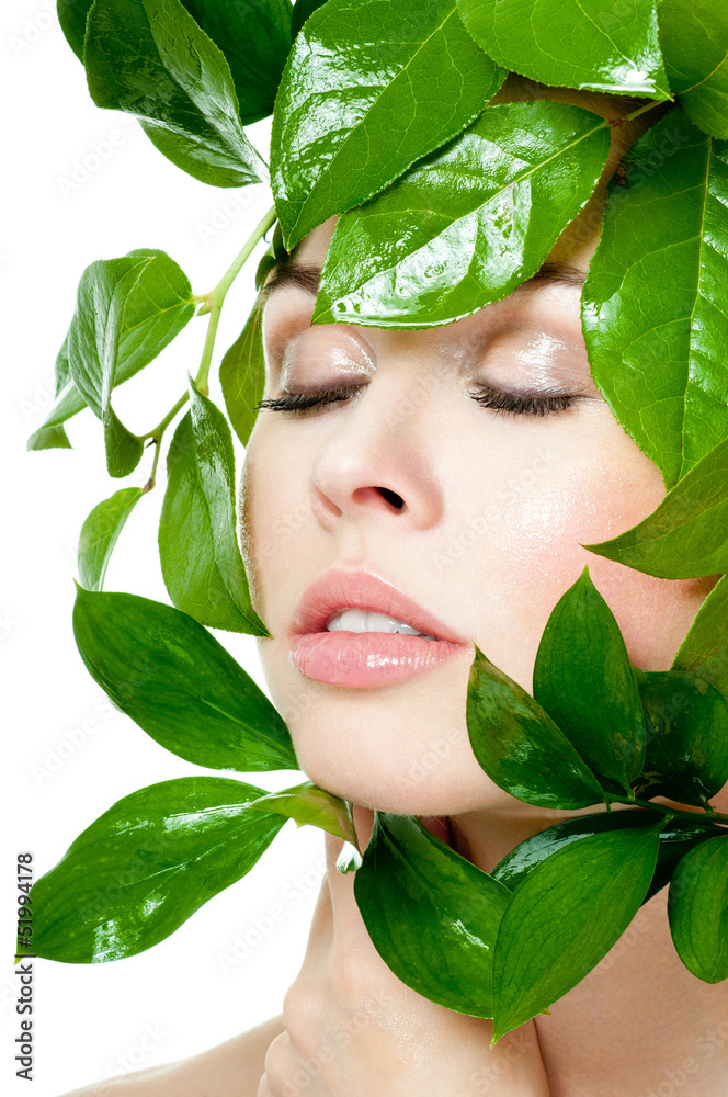 beautiful woman's face, surrounded by green leaves beautiful woman's face, surrounded by green leaves
